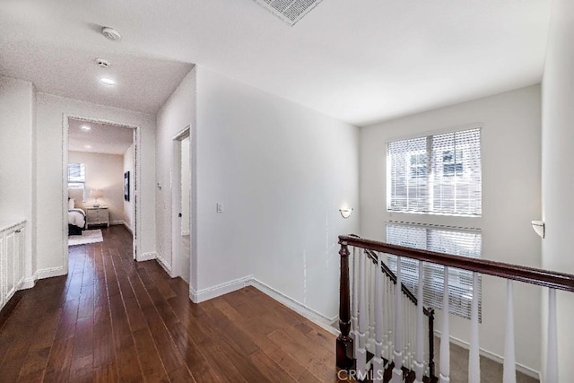 hallway with radiator heating unit and dark wood-type flooring