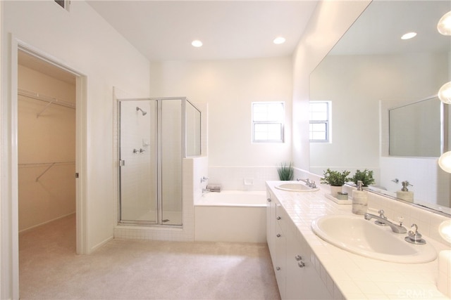 bathroom featuring shower with separate bathtub and vanity