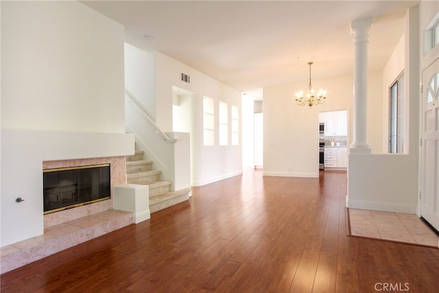 unfurnished living room featuring a chandelier, hardwood / wood-style floors, and a premium fireplace