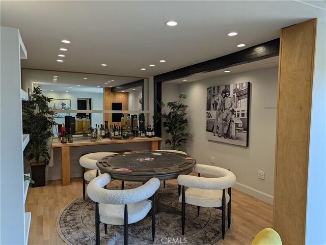 dining space with a dry bar, recessed lighting, wood finished floors, and baseboards