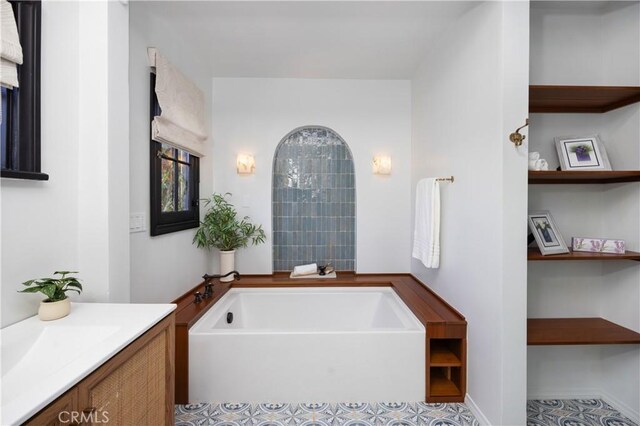 bathroom with a tub to relax in and vanity