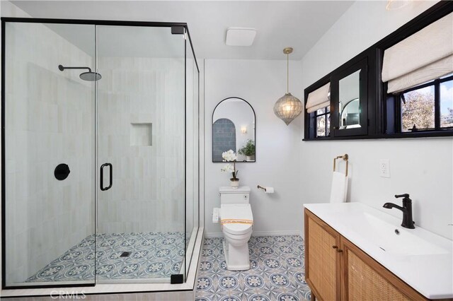 bathroom with vanity, a shower with shower door, and toilet