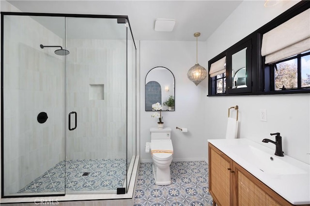 bathroom with baseboards, toilet, a stall shower, and vanity