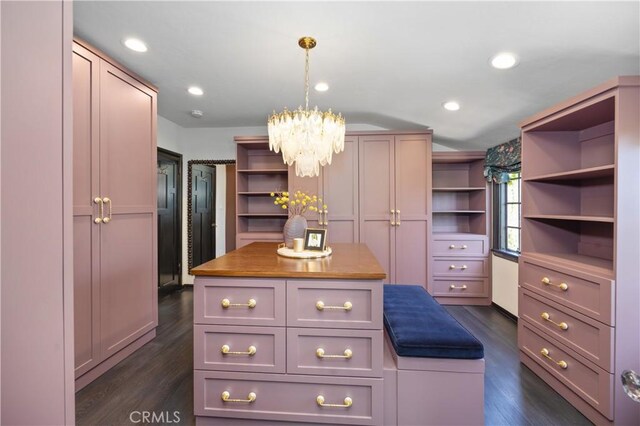 spacious closet with a notable chandelier and dark hardwood / wood-style floors