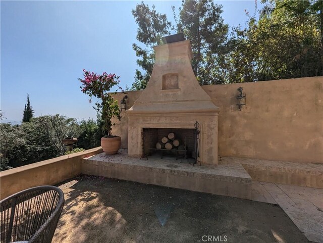 view of patio with an outdoor fireplace