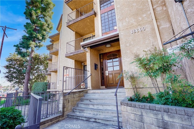 view of exterior entry featuring a balcony