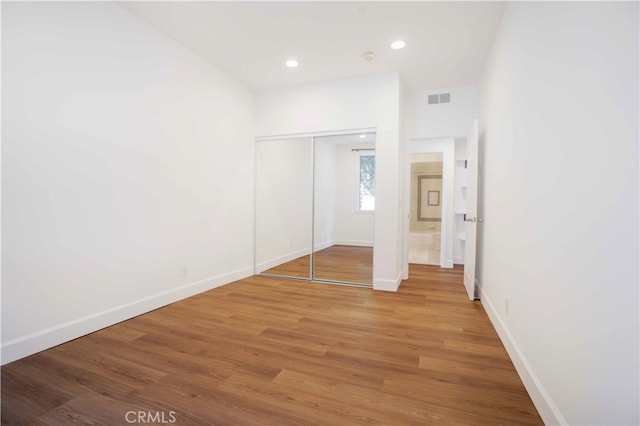 unfurnished bedroom with hardwood / wood-style flooring and a closet