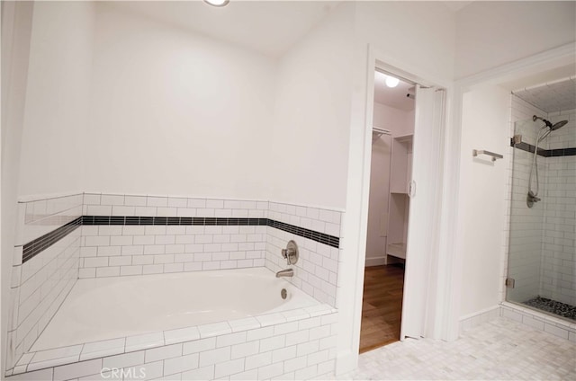 bathroom featuring wood-type flooring and plus walk in shower