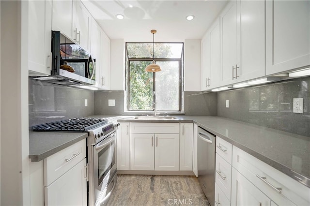 kitchen featuring stainless steel appliances, backsplash, and white cabinets