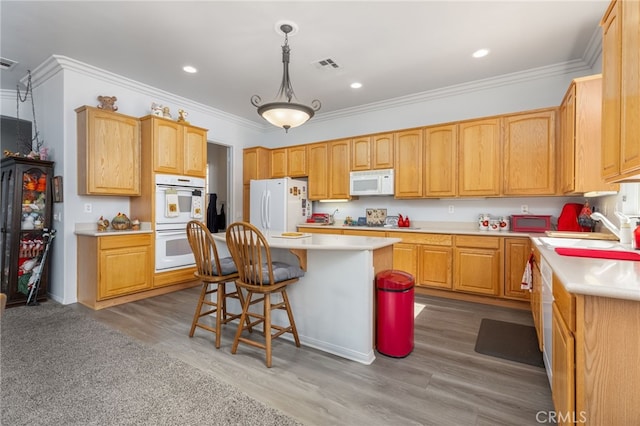 kitchen featuring light hardwood / wood-style floors, sink, white appliances, and a kitchen island