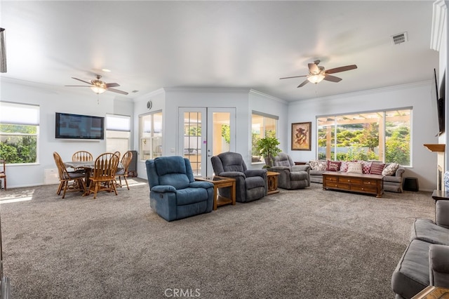 carpeted living room with ceiling fan, ornamental molding, and a healthy amount of sunlight