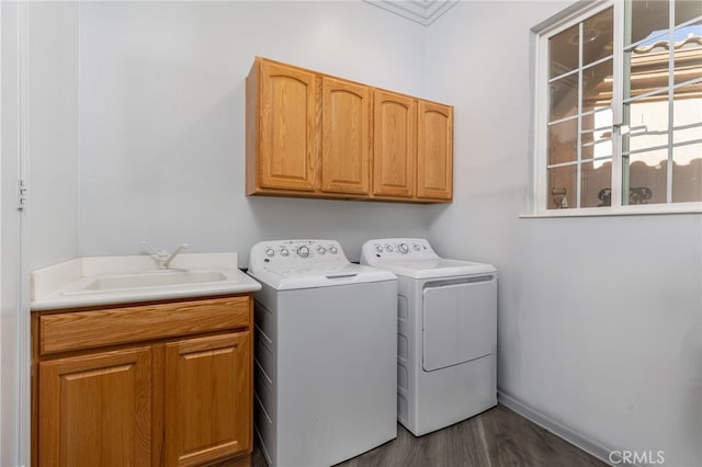 laundry room with hardwood / wood-style flooring, sink, crown molding, cabinets, and washer and dryer