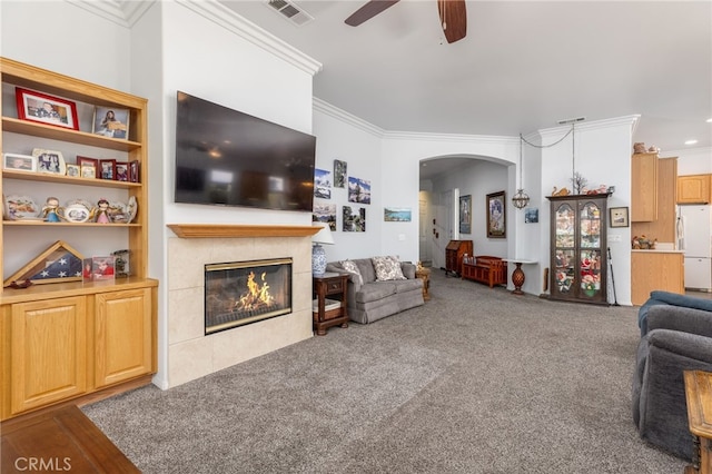 carpeted living room featuring ornamental molding, a fireplace, and ceiling fan