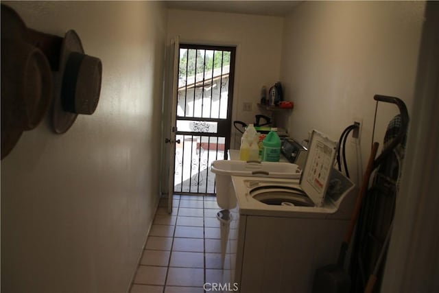 clothes washing area with light tile patterned floors and washing machine and dryer