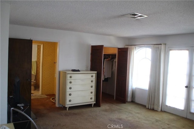 unfurnished bedroom with a closet, light carpet, and a textured ceiling