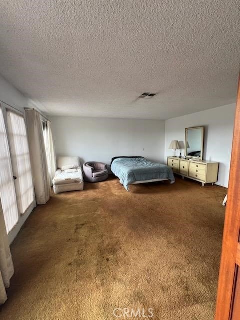 unfurnished bedroom featuring a textured ceiling and carpet flooring