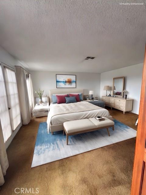 carpeted bedroom featuring a textured ceiling