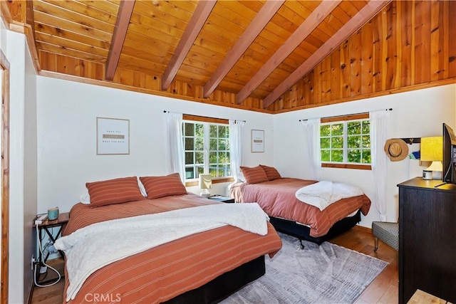 bedroom with hardwood / wood-style flooring, beam ceiling, high vaulted ceiling, and multiple windows