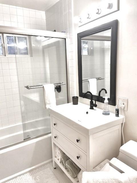 full bathroom with tile patterned flooring, vanity, toilet, and enclosed tub / shower combo