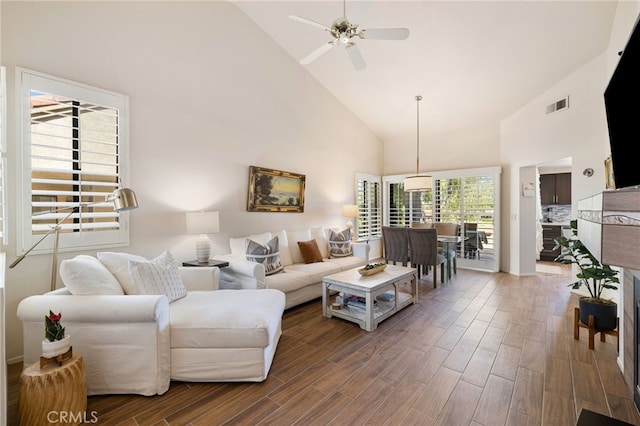 living room featuring high vaulted ceiling, ceiling fan, wood-type flooring, and a wealth of natural light