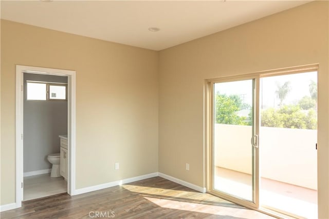 unfurnished room featuring a wealth of natural light and hardwood / wood-style floors