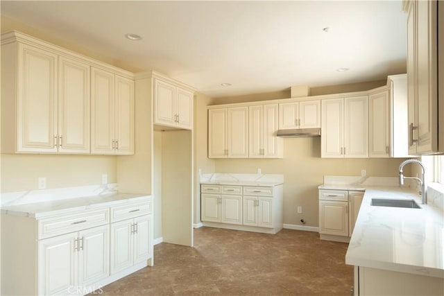 kitchen with light stone counters and sink