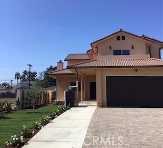 mediterranean / spanish house with a front lawn and a garage