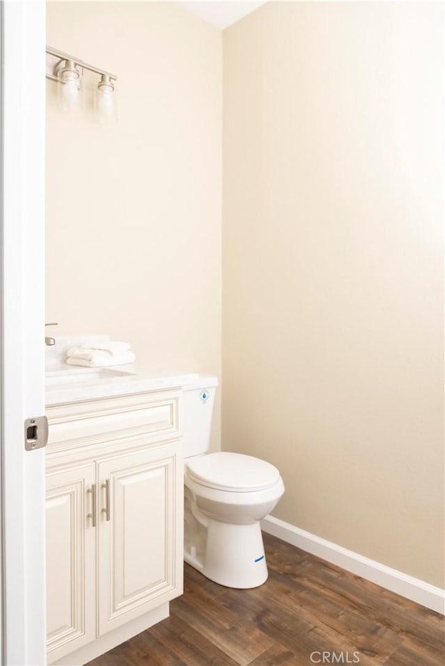 bathroom with vanity, toilet, and wood-type flooring