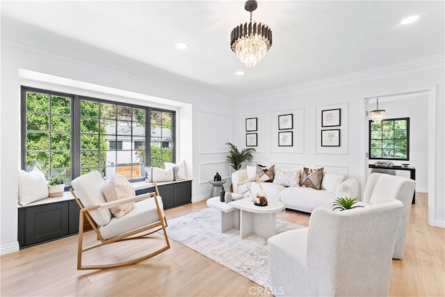 living room featuring light wood-type flooring, a healthy amount of sunlight, and a notable chandelier