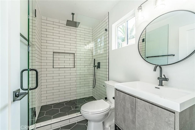 bathroom with tile patterned flooring, vanity, toilet, and a shower with door