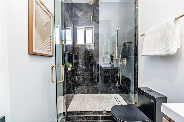 bathroom featuring vanity, toilet, and a shower with door