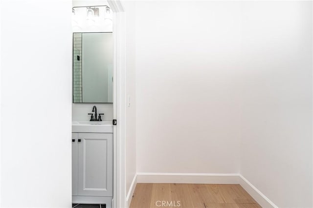 hallway with sink and light hardwood / wood-style floors