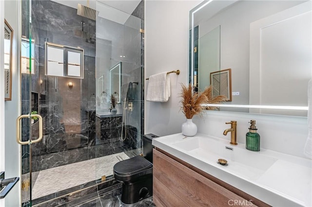 bathroom featuring a shower with door, vanity, and toilet