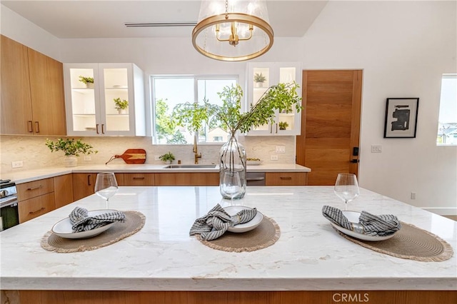 kitchen featuring decorative backsplash, plenty of natural light, and light stone counters