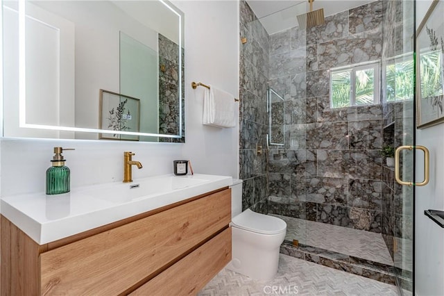 bathroom with vanity, toilet, and a shower with shower door