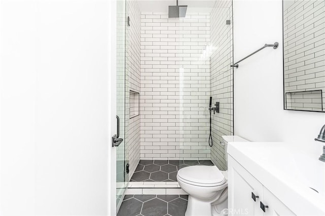 bathroom with tile patterned floors, walk in shower, vanity, and toilet