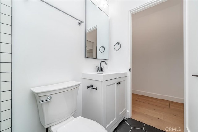 bathroom featuring vanity, wood-type flooring, and toilet