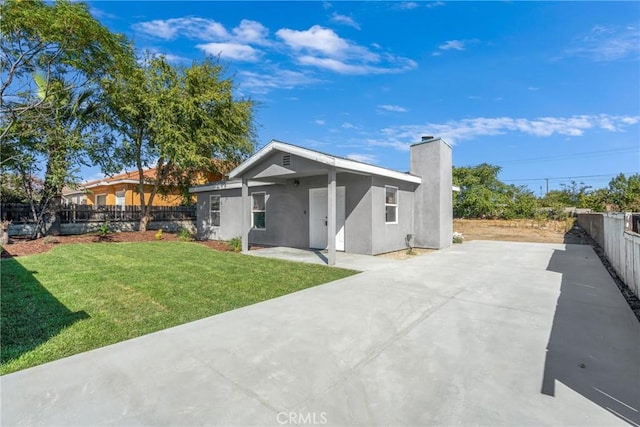 rear view of property featuring a lawn and a patio