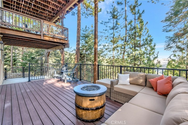 wooden deck featuring an outdoor living space with a fire pit