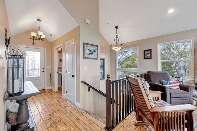 entryway featuring lofted ceiling, an inviting chandelier, and light hardwood / wood-style flooring