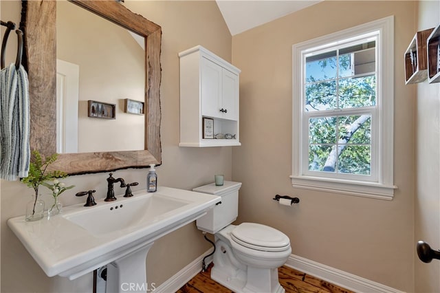 bathroom with lofted ceiling, hardwood / wood-style floors, and toilet