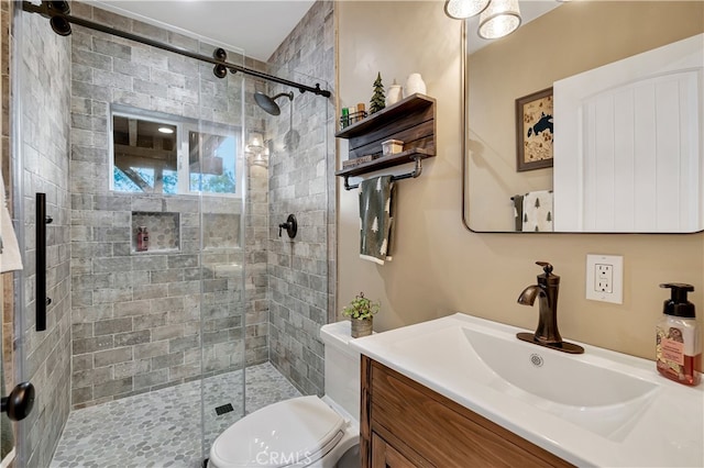 bathroom with walk in shower, vanity, and toilet