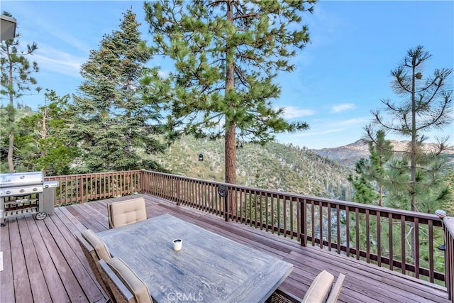 deck with area for grilling and a mountain view