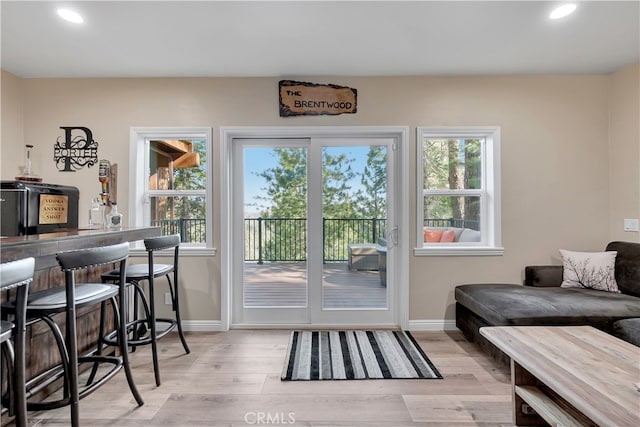 doorway to outside with bar and light hardwood / wood-style floors