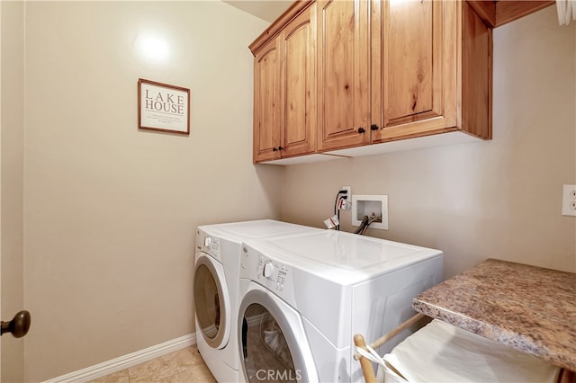 laundry area with washer and dryer, light tile patterned floors, and cabinets