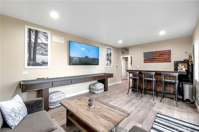 living room featuring light hardwood / wood-style floors and bar area