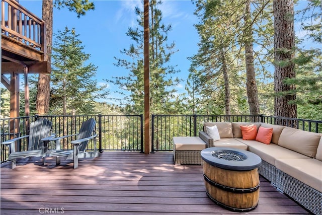 wooden terrace with an outdoor living space with a fire pit