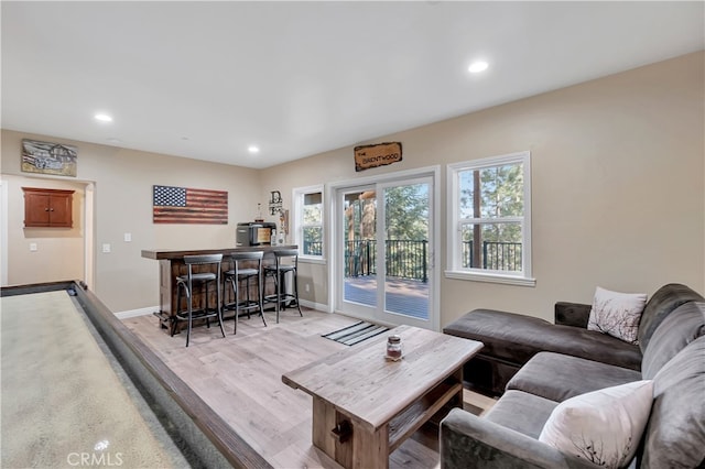 living room featuring light wood-type flooring and indoor bar