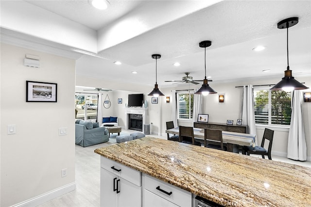 kitchen featuring ceiling fan, decorative light fixtures, a wealth of natural light, and white cabinetry