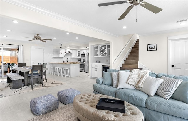 living room featuring crown molding and ceiling fan